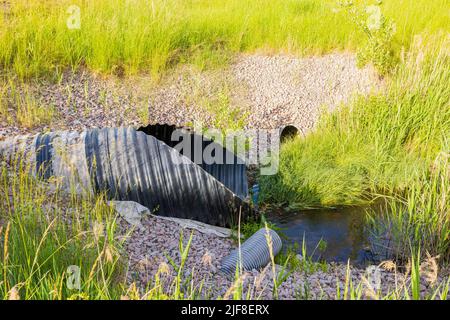 Nahaufnahme der Entwässerungsleitungen, die auf der Straßenseite herauskommen. Gebäudetechnikkonzept. Stockfoto