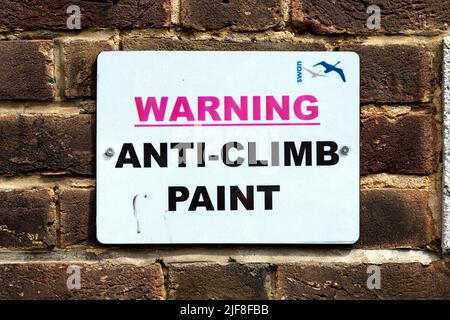 Warnschild Anti-Climb Farbe auf einer Ziegelwand Stockfoto