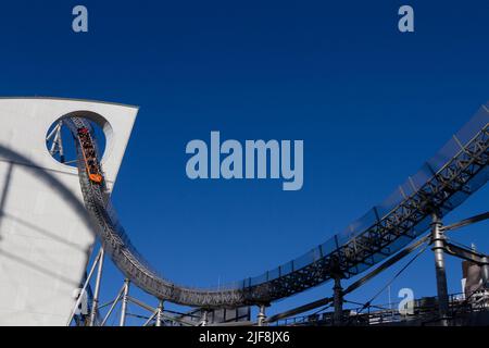 Die Achterbahn Thunder Dolphin geht durch ein Loch im LaQua-Gebäude im Tokyo Dome City Vergnügungspark, Tokio, Japan. Stockfoto