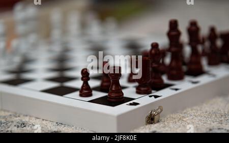 Nahaufnahme der angeordneten braunen Figuren auf einem Schachbrett Stockfoto