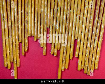 Gesalzene Sticks. Süßwaren auf dem Tisch. Salzige Backwaren. Snack für Bier. Ein Stück Teig auf einer Tischdecke. Keine gesunde Ernährung Stockfoto