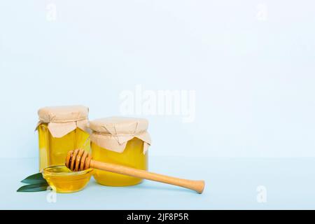 Honig im Glas mit Blättern und Honigtaube auf farbigem Hintergrund Draufsicht mit Text kopieren. Stockfoto