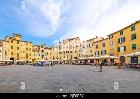 Straßencafés auf der Piazza del Anfiteatro, dem antiken Amphitheater in der von der toskanischen Stadtmauer umgebenen Stadt Lucca, Italien. Stockfoto
