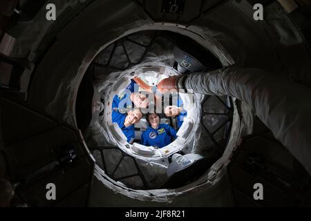 Expedition 67 Flight Engineers (von unten im Uhrzeigersinn) Samantha Cristoforetti, Bob Hines, Kjell Lindgren und Jessica Watkins lächeln für ein Porträt aus dem Inneren des Boeing CST-100 Starliner-Crew-Schiffes. Das Quartett blickt durch den vorwärtsgerichteten internationalen Docking-Adapter des Harmony-Moduls, an den Starliner angedockt ist, und in die Internationale Raumstation am 24. Mai 2022. Quelle: NASA über CNP Stockfoto