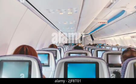 Bild des Flugzeugscreengeräts für Unterhaltung für den Passagier zuschneiden. Fliegen mit dem Flugzeug. Reisekonzept. Selektiver Fokus. Stockfoto