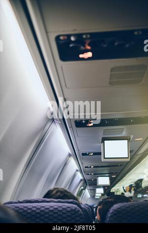 Bild des Flugzeugscreengeräts für Unterhaltung für den Passagier zuschneiden. Fliegen mit dem Flugzeug. Reisekonzept. Stockfoto