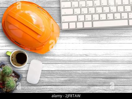 Oranger Schutzhelm, Kaktus, Mini-Maus und Tastatur kabellos und Tasse Kaffee auf weißem Holztisch Hintergrund im Büro Schreibtisch oder Arbeitsplatz. Techniker wo Stockfoto