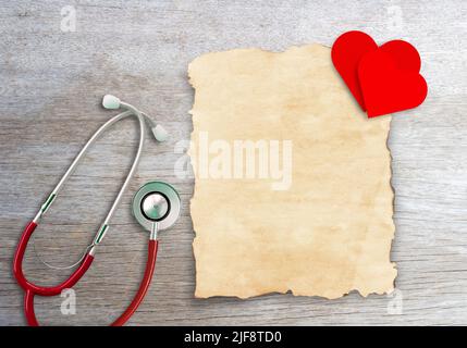 Altes Papier und rotes Papierherz auf Holztischhintergrund. Stockfoto
