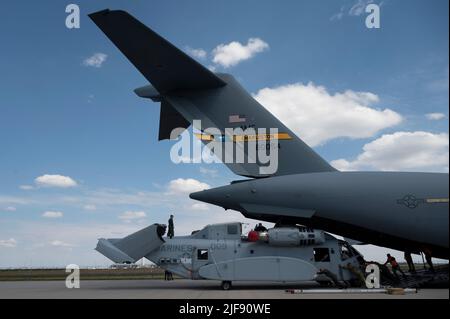 US Air Force-Besatzung der 16. Airlift Squadron und US-Marineinfanteristen der Marine Test and Evaluation Squadron-1, Luftbrücke und Entladung eines CH-53K King Hengst Hubschraubers von einer US Air Force C-17 Globemaster III nach Berlin, Deutschland, 15. Juni 2022. Die C-17 ist das flexibelste Frachtflugzeug der Luftwaffe, das in der Lage ist, Truppen und Fracht schnell strategisch zu fliegen. (USA Air Force Foto von Tech. Sgt. Daniel Asselta) Stockfoto