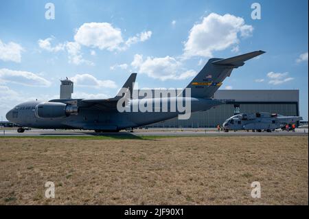 US Air Force-Besatzung der 16. Airlift Squadron und US-Marineinfanteristen der Marine Test and Evaluation Squadron-1, Luftbrücke und Entladung eines CH-53K King Hengst Hubschraubers von einer US Air Force C-17 Globemaster III nach Berlin, Deutschland, 15. Juni 2022. Die C-17 ist das flexibelste Frachtflugzeug der Luftwaffe, das in der Lage ist, Truppen und Fracht schnell strategisch zu fliegen. (USA Air Force Foto von Tech. Sgt. Daniel Asselta) Stockfoto