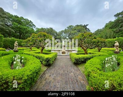 Formeller Garten mit Statuen, Brunnen, Ziegelsteinsteg und gepflegten Hecken im Elizabethan Garden, Fort Raleigh, Roanoke Island, North Carolina. Stockfoto