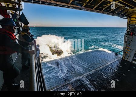 PAZIFISCHER OZEAN (23. Juni 2022) ein amphibisches Kampffahrzeug, das an das 3D Assault Amphibian Bataillon, 1. Marine Division, angeschlossen ist, landet während des Wassertrainings im Pazifischen Ozean am 23. Juni 2022 am Brunnendeck des amphibischen Transportschiffes USS John P. Murtha (LPD 26). John P. Murtha führt derzeit Routineoperationen in der US 3.-Flotte durch. (USA Navy Foto von Mass Communication Specialist 2. Class Curtis D. Spencer) Stockfoto