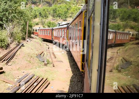 Toy Train bewegt sich auf Berghängen, schöne Aussicht, eine Seite Berg, eine Seite Tal bewegt sich auf der Eisenbahn auf den Hügel, inmitten grüner Naturwald. Spielzeug Stockfoto