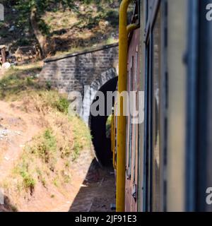 Toy Train bewegt sich auf Berghängen, schöne Aussicht, eine Seite Berg, eine Seite Tal bewegt sich auf der Eisenbahn auf den Hügel, inmitten grüner Naturwald. Spielzeug Stockfoto