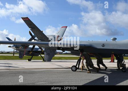 Mitglieder der US-Luftwaffe des Angriffsflügels 174., der New York Air National Guard und des 119.-Flügels der North Dakota Air National Guard arbeiten als geschlossene Einheit daran, während der Übung Valliant Shield, 7. Juni 2022, MQ-9 Reaper auf der Anderson Air Force Base, Guam, zu starten. Valiant Shield 2022 war eine 12-tägige gemeinsame Field Training Exercise (FTX), die darauf abzielte, die Integration zwischen den US-Streitkräften durch gemeinsame Einsätze auf See, zu Land, in der Luft und im Cyberspace zu verbessern. Es bot den Mitgliedern des MQ-9-Unternehmens die Möglichkeit, zusammenzuarbeiten und einen Unterschied zu machen und gleichzeitig dynamische Kräfte zu schaffen Stockfoto