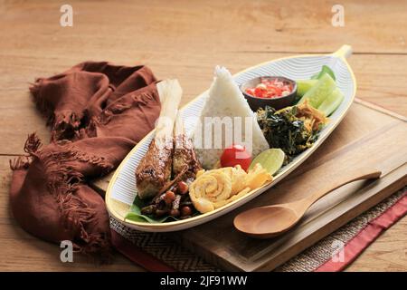 Nasi Campur Bali. Balinesisches Gericht aus gedämpftem Reis mit verschiedenen Beilagen wie Sate Lilit, Ayam Pelalah, Telur Dadar, Kacang Teri, Jukut Urap. O Stockfoto