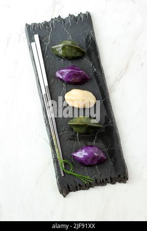 Top Korean Reiskuchen mit Erdnussfüllung, Songpyeon. Auf Schwarzem, Teller Weißem Tisch Stockfoto