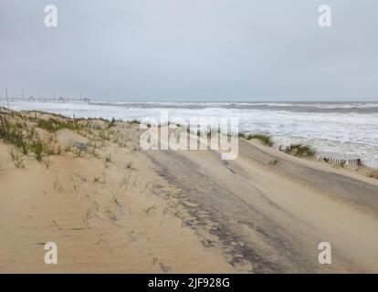 Stürmischer Atlantischer Ozean bei Nags Head in den Outer Banks mit Jennettes Fischerpier im Hintergrund. Fotografiert während eines Nor'easter. Stockfoto