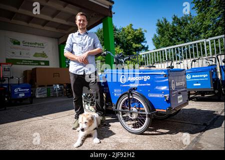 Berlin, Deutschland. 10.. Juni 2022. Matti Schurr, CEO und Mitbegründer von Avocargo, steht neben einem der Lastenräder seines Unternehmens vor dem Motionlab Berlin. Das Berliner Startup Avocargo bietet in Berlin E-Laderäder an und plant, sein Angebot in diesem Jahr auf andere Städte auszuweiten. (To dpa 'Mission 'make Mainstream' - Städte wollen Lastenfahrräder etablieren') Quelle: Fabian Sommer/dpa/Alamy Live News Stockfoto