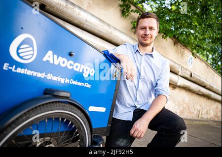 Berlin, Deutschland. 10.. Juni 2022. Matti Schurr, CEO und Mitbegründer von Avocargo, kniet vor dem Motionlab Berlin neben einem der Lastenräder seines Unternehmens. Das Berliner Startup Avocargo bietet in Berlin E-Laderäder an und plant, sein Angebot in diesem Jahr auf andere Städte auszuweiten. (To dpa 'Mission 'make Mainstream' - Städte wollen Lastenfahrräder etablieren') Quelle: Fabian Sommer/dpa/Alamy Live News Stockfoto