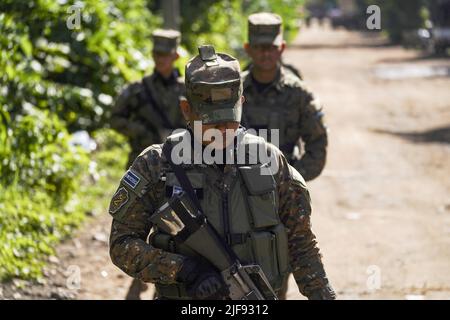 Santa Ana, El Salvador. 30.. Juni 2022. Soldaten patrouillieren im Viertel La Realidad. Die salvadorianische Regierung nahm drei Bandenmitglieder der Bande Barrio 18 Sureños gefangen, nachdem am 28. Juni drei Polizisten getötet wurden, während der Sicherheitsaufgaben, die Teil des Kongresses im Rahmen der Genehmigung des Ausnahmezustands gegen Banden, die mehr als 40.000 mutmaßliche Kriminelle inhaftiert haben, stattfand. Kredit: SOPA Images Limited/Alamy Live Nachrichten Stockfoto