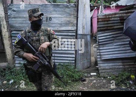 Santa Ana, El Salvador. 30.. Juni 2022. Ein Soldat schaut auf, während er im Viertel 'La Realidad' patrouilliert. Die salvadorianische Regierung nahm drei Bandenmitglieder der Bande Barrio 18 Sureños gefangen, nachdem am 28. Juni drei Polizisten getötet wurden, während der Sicherheitsaufgaben, die Teil des Kongresses im Rahmen der Genehmigung des Ausnahmezustands gegen Banden, die mehr als 40.000 mutmaßliche Kriminelle inhaftiert haben, stattfand. Kredit: SOPA Images Limited/Alamy Live Nachrichten Stockfoto