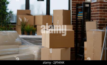 Niemand in der Wohnung des Wohnzimmers, voll von Kartons mit Möbeln und Dingen, Stapeln von beweglichen Ladungslagern. Keine Menschen in leeren Wohnungen mit Versandcontainern. Stockfoto