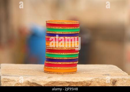 Einige bunte Armreifen auf Stein gelegt Stockfoto