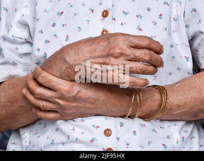 Hände der älteren asiatischen Frau. Konzept der rheumatoider Arthritis, Arthrose, Dehnung des Handgelenks oder Gelenkschmerzen. Stockfoto