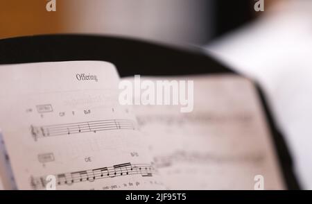 Nahaufnahme des Textes oder Wortes „Angebot“. Die christliche Hymne, die Noten oder Noten mit Noten für den Chor oder die Musiker anbietet. Stockfoto