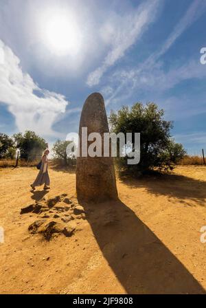 Der isolierte Menir dos Almendres, neolithisch stehender Stein, der etwa 4,5 Meter oder 14,76 Fuß hoch ist, und etwa eineinhalb Kilometer weiter Stockfoto