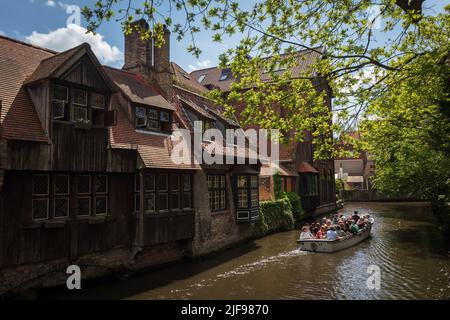 Touristen auf einem Boot überqueren den Kanal um die Bonifacius-Brücke, eine romantische kleine Ecke von Brügge. Belgien. Stockfoto