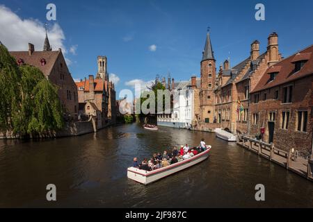 Ein Touristenboot, das den Kanal von Rozenhoedkaai, den Rosenkranz Quay, überquert, einer der beliebtesten Orte in Brügge. Belgien. Stockfoto