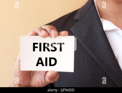 ERSTE-HILFE-Wort auf der weißen Karte, die von einem präsentiert wird Geschäftsmann Stockfoto