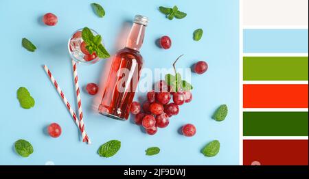 Flasche frische Limonade mit Trauben auf blauem Hintergrund. Unterschiedliche Farbmuster Stockfoto