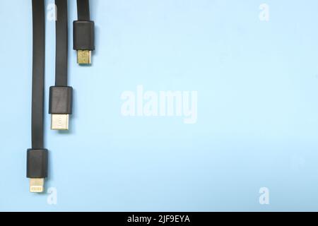 Smartphone oder Mobiltelefon Standard-Ladekabel Stecker flach legen. Micro-USB, Typ c und Blitzkabel auf blauem Hintergrund mit Kopierplatz. Stockfoto