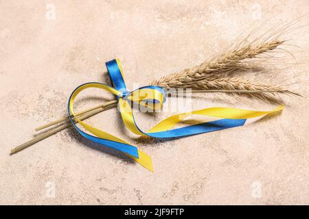 Weizenspikelets und Bänder in den Farben der ukrainischen Flagge auf grunge Hintergrund Stockfoto