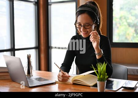Fröhliche und freundliche junge asiatische weibliche Online-freiberufliche Tutor oder Lehrer Lehre und Coaching ihrer Schüler im Online-Klasse über Laptop-Computer. Stockfoto