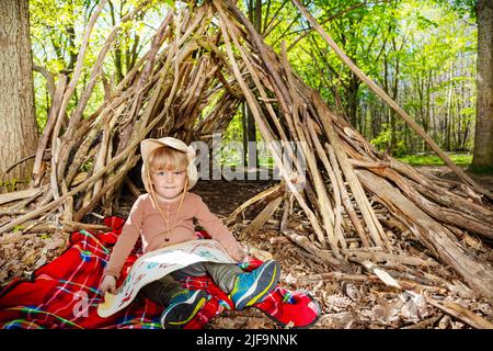 Junge in Pfadfinder-Hut sitzen mit Schatzkarte spielen Schatz Stockfoto