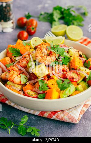 Gesunder Shrimp-Mango-Salat mit Avocado, Kirschtomaten und Zwiebeln, garniert mit frischem Cilantro Stockfoto