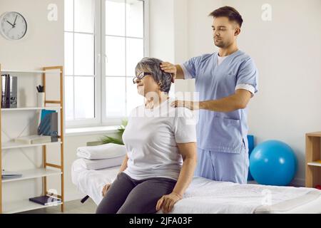 Chiropraktiker, Osteopathin oder Manualtherapeut massieren Nacken und Schultern älterer Frauen Stockfoto