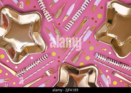 Party Flat Lay mit goldener und weißer Dekoration wie Teller, Konfetti und Federn auf rosa Hintergrund Stockfoto