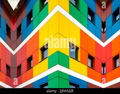 Mehrfarbige Fassaden der Schule mit schwarzen Fensterrahmen. Blick vom blauen Himmel, farbigen Gebäude Carabanchel, Madrid, Spanien Stockfoto