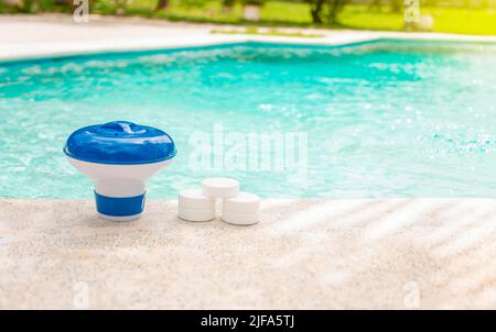 Schwimmbadfloat und Chlortabletten, Nahaufnahme eines Schwimmbads und Chlortabletten am Rand eines Schwimmbads. Tabletten mit Chlorspender für Stockfoto