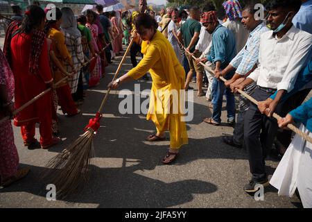 Kathmandu, NE, Nepal. 1.. Juli 2022. Ein Anhänger säubert die Straße, während andere Menschen während der Jagannath Rath Yatra, einer Kulturprozession in Kathmandu, Nepal, am 1. Juli 2022, den Wagen von Lord Jagannath ziehen. (Bild: © Aryan Dhimal/ZUMA Press Wire) Bild: ZUMA Press, Inc./Alamy Live News Stockfoto