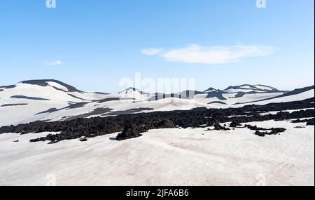 Karge hügelige Vulkanlandschaft aus Schnee und vulkanischem Gestein, Wanderweg Fimmvoerouhals, Porsmoerk Nature Reserve, Suourland, Island Stockfoto