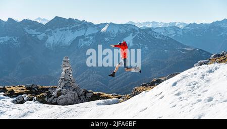 Bergsteigerspringen, neben einer Kairon, vor verschneiten Bergen des Rofan, Wanderweg zum Guffert mit Erstschnee, im Herbst Stockfoto