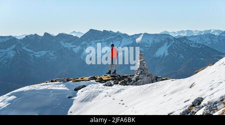 Bergsteiger neben einer Kairon, vor verschneiten Bergen des Rofan, Wanderweg zum Guffert mit Erstschnee, im Herbst Brandenberger Alpen Stockfoto