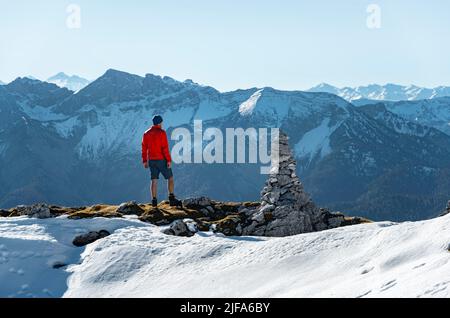 Bergsteiger neben einer Kairon, vor verschneiten Bergen des Rofan, Wanderweg zum Guffert mit Erstschnee, im Herbst Brandenberger Alpen Stockfoto