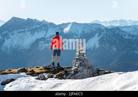 Bergsteiger neben einer Kairon, vor verschneiten Bergen des Rofan, Wanderweg zum Guffert mit Erstschnee, im Herbst Brandenberger Alpen Stockfoto